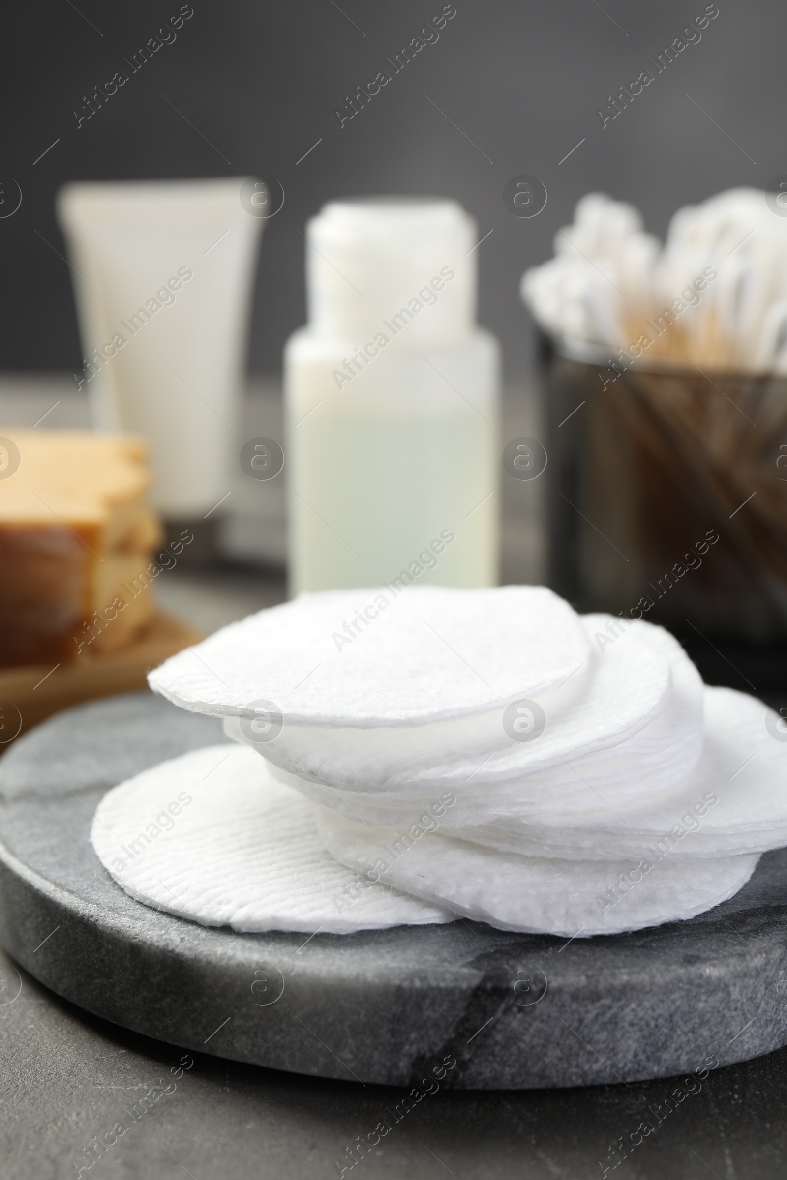 Photo of Many cotton pads on grey textured table, closeup