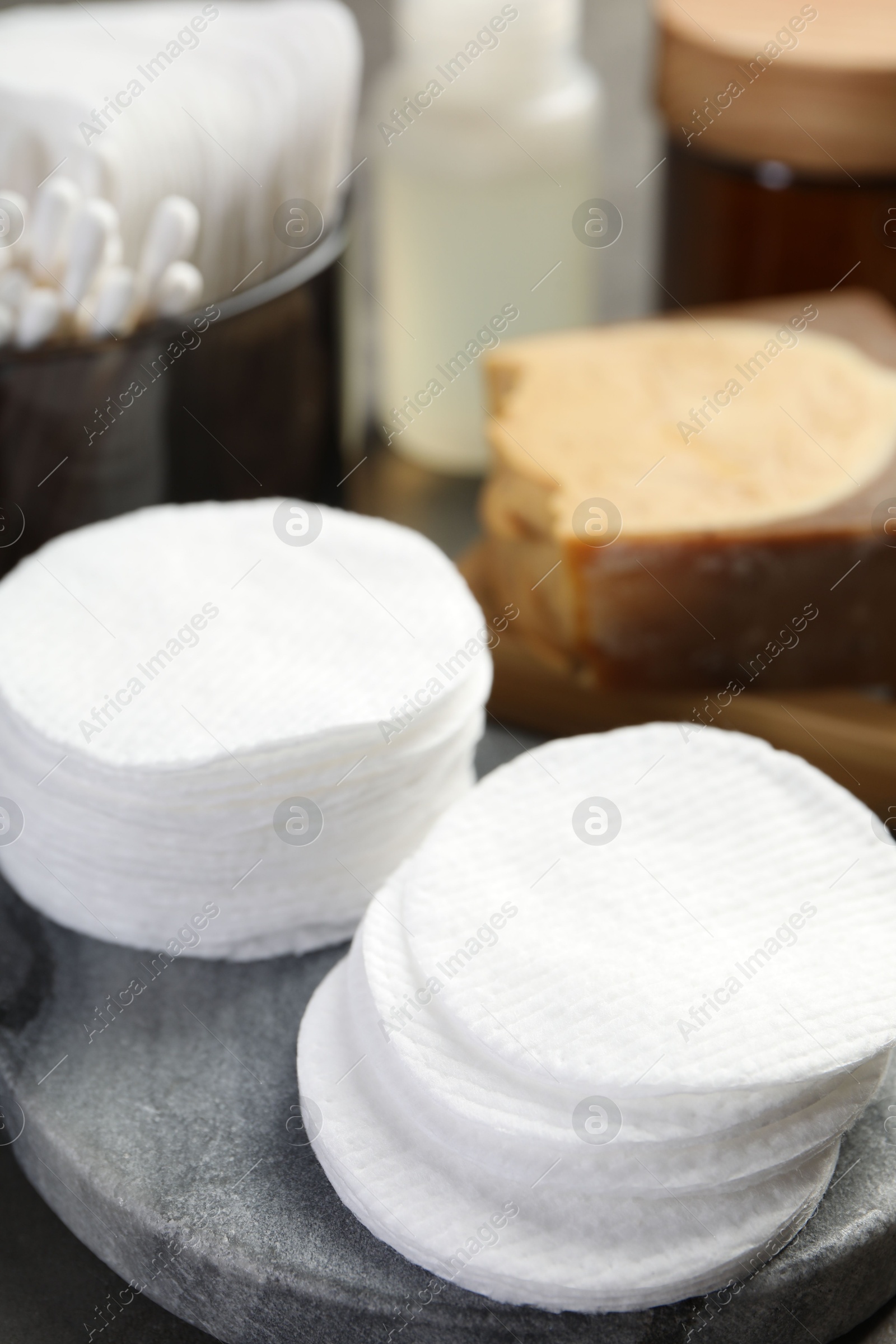 Photo of Many cotton pads and other toiletries on table, closeup