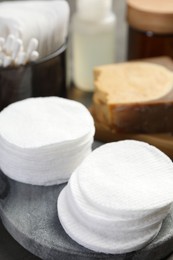 Photo of Many cotton pads and other toiletries on table, closeup