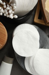 Photo of Many cotton pads and other toiletries on grey table, flat lay