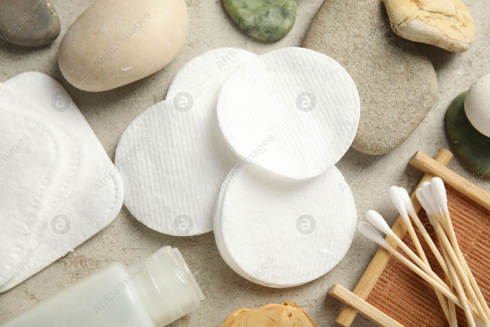 Photo of Flat lay composition with cotton pads and swabs on grey textured table