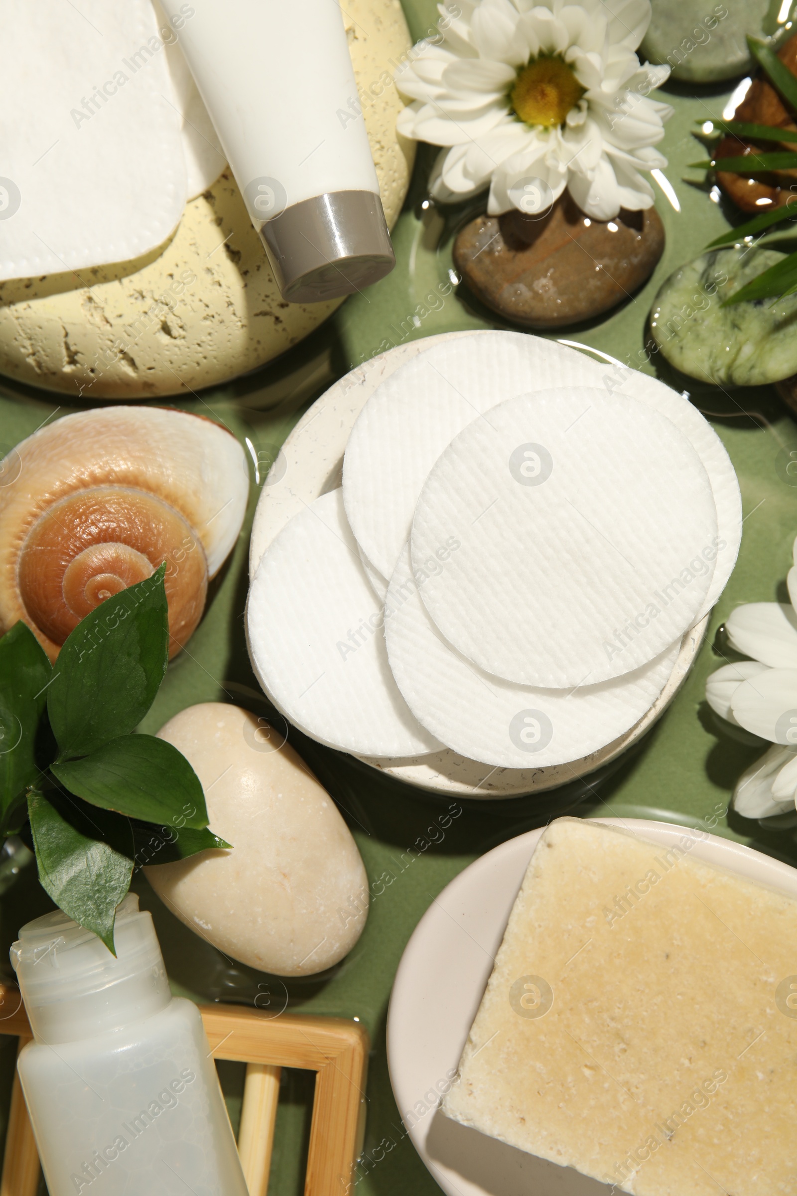 Photo of Flat lay composition with cotton pads and swabs on green table