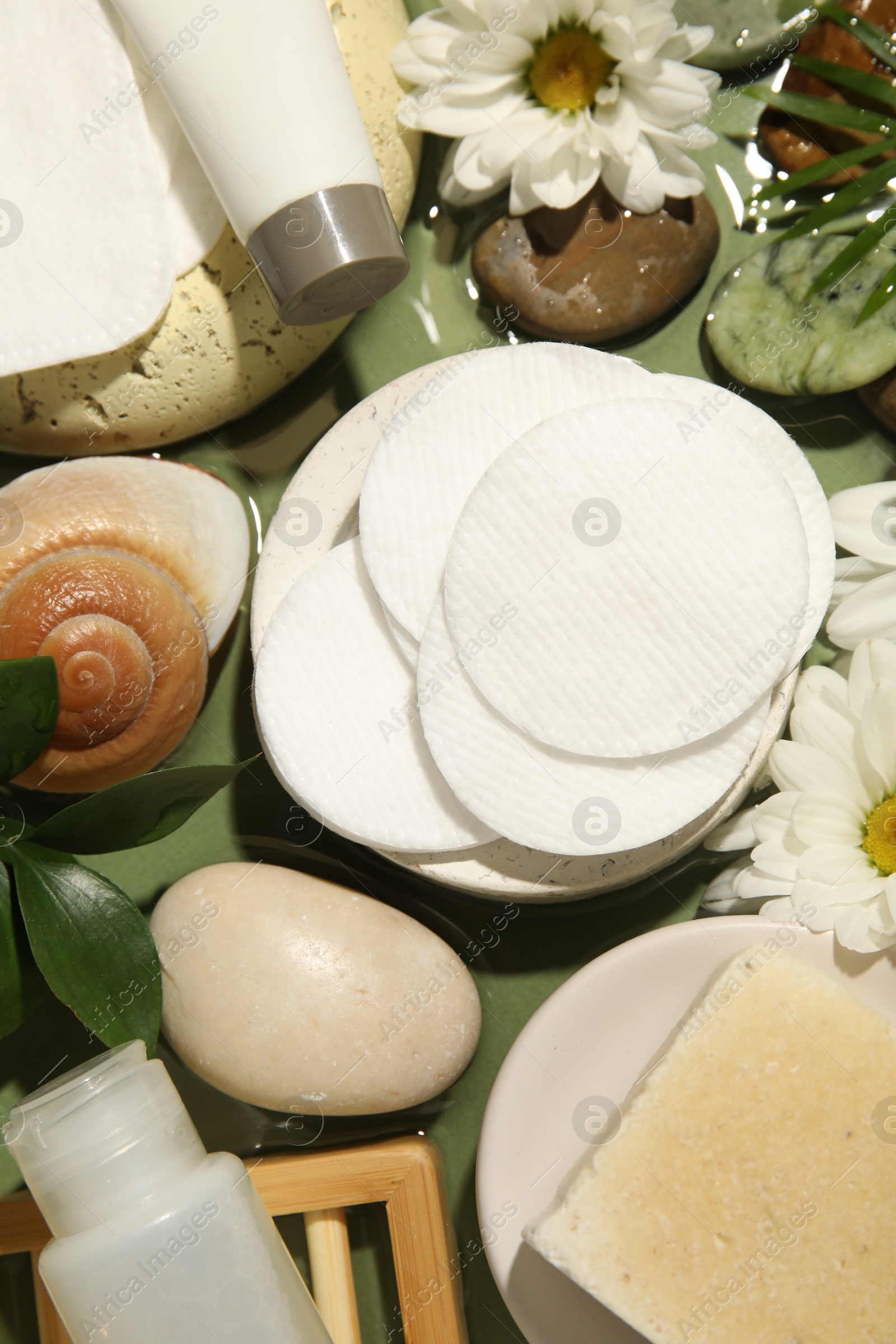 Photo of Flat lay composition with cotton pads and swabs on green table