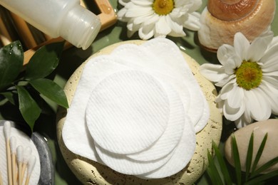 Photo of Flat lay composition with cotton pads and swabs on green table