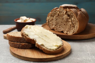 Photo of Fresh bread with butter on grey table, closeup