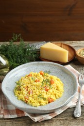 Photo of Delicious pumpkin risotto served on wooden table, closeup