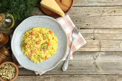 Photo of Delicious pumpkin risotto served on wooden table, flat lay. Space for text