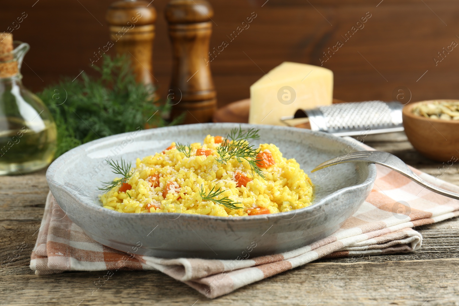 Photo of Delicious pumpkin risotto served on wooden table, closeup