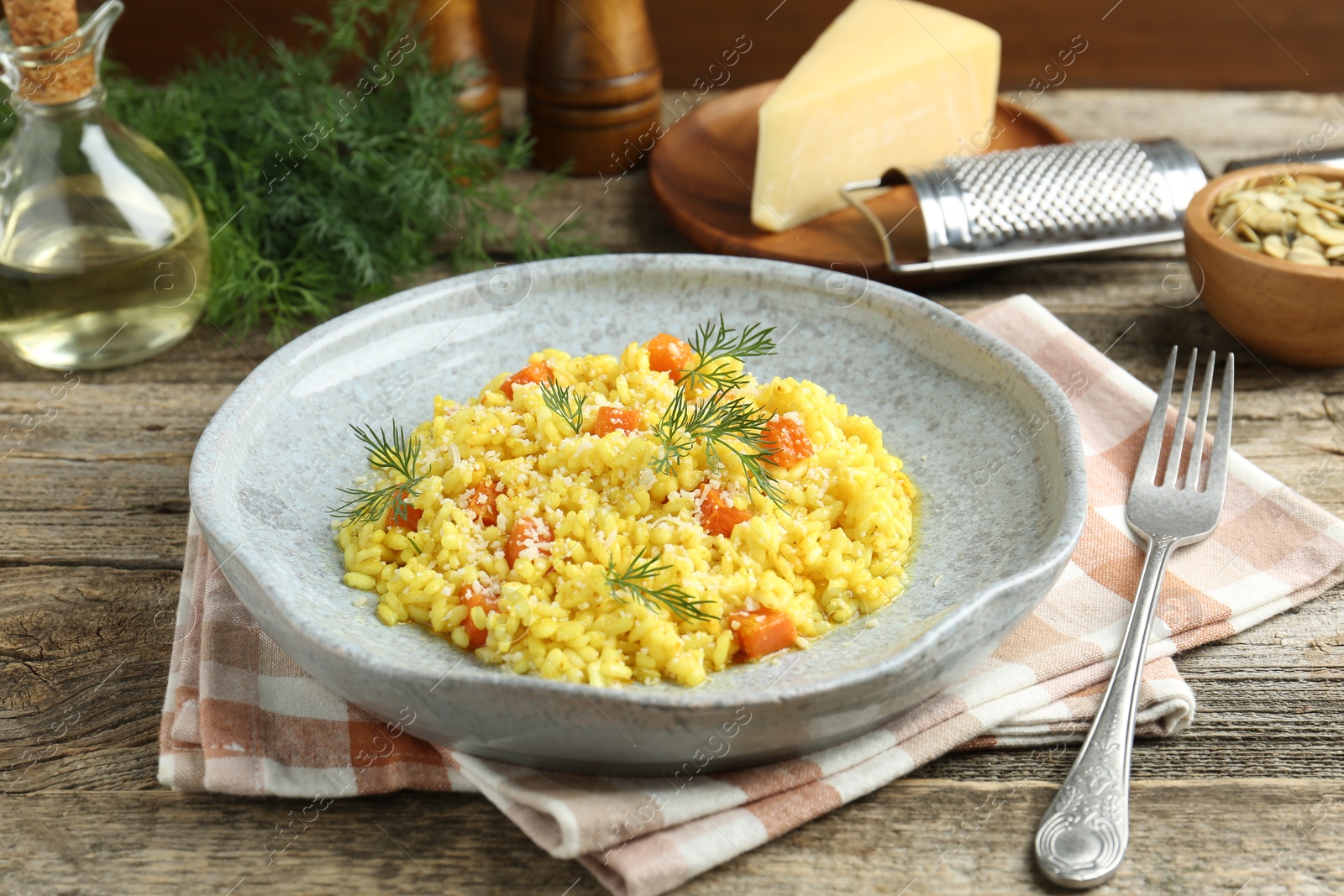 Delicious pumpkin risotto served on wooden table, closeup Photo of Delicious pumpkin risotto served on wooden table, closeup