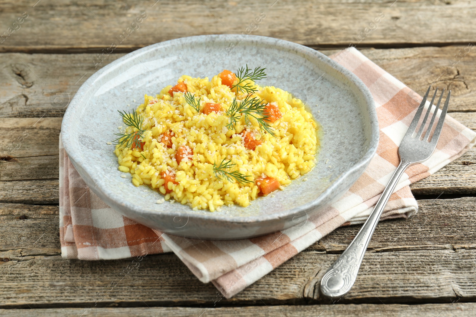 Photo of Delicious pumpkin risotto served on wooden table, closeup