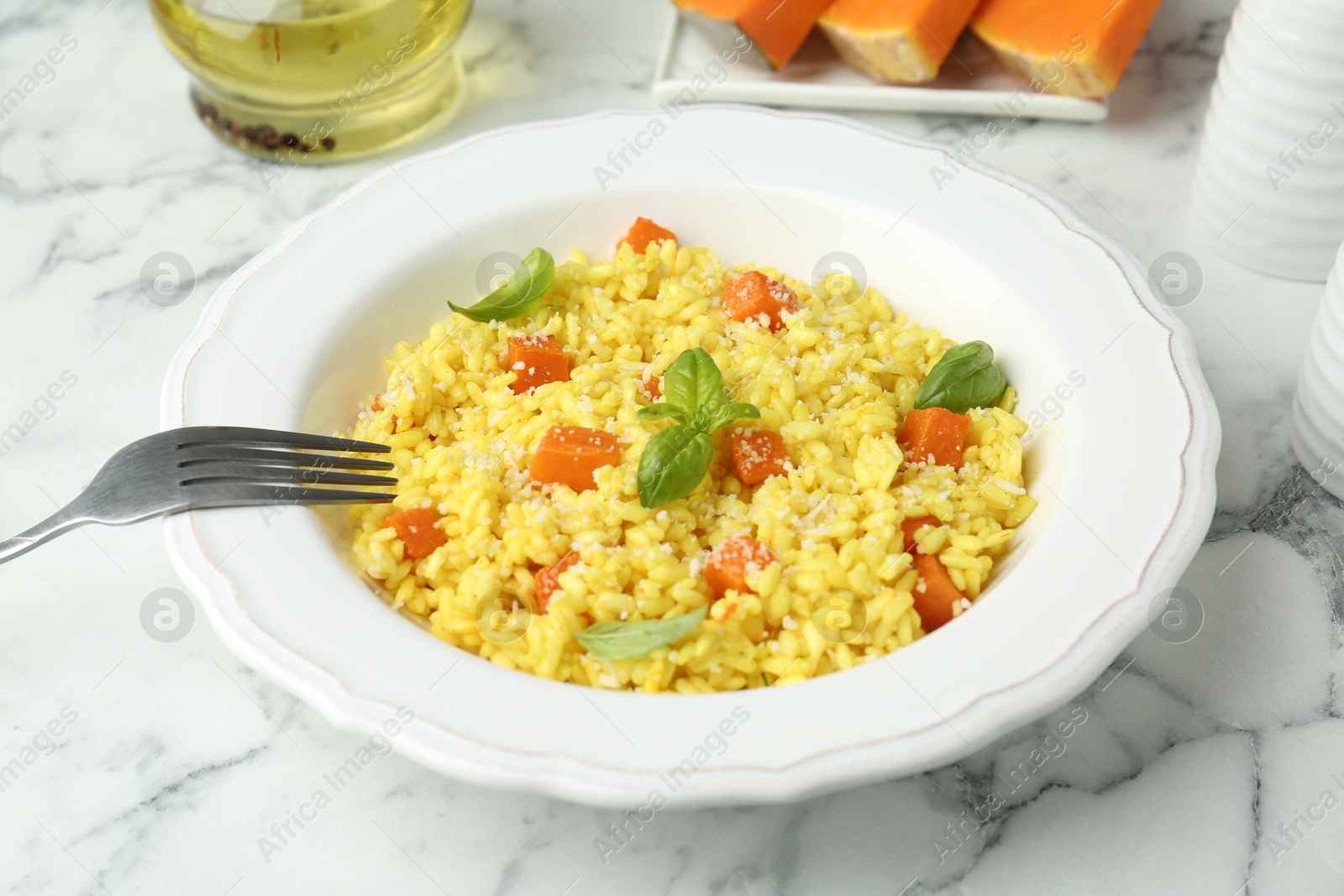 Photo of Delicious pumpkin risotto served on white marble table, closeup