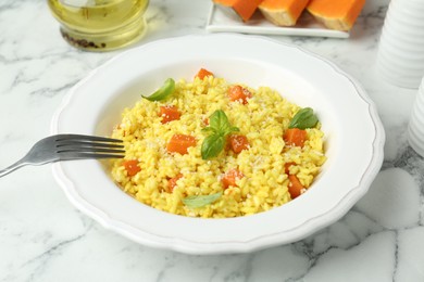 Photo of Delicious pumpkin risotto served on white marble table, closeup