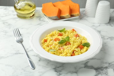 Photo of Delicious pumpkin risotto served on white marble table, closeup