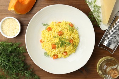 Photo of Delicious pumpkin risotto on wooden table, flat lay