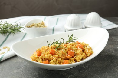 Photo of Delicious pumpkin risotto on grey table, closeup