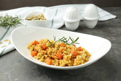 Photo of Delicious pumpkin risotto on grey table, closeup