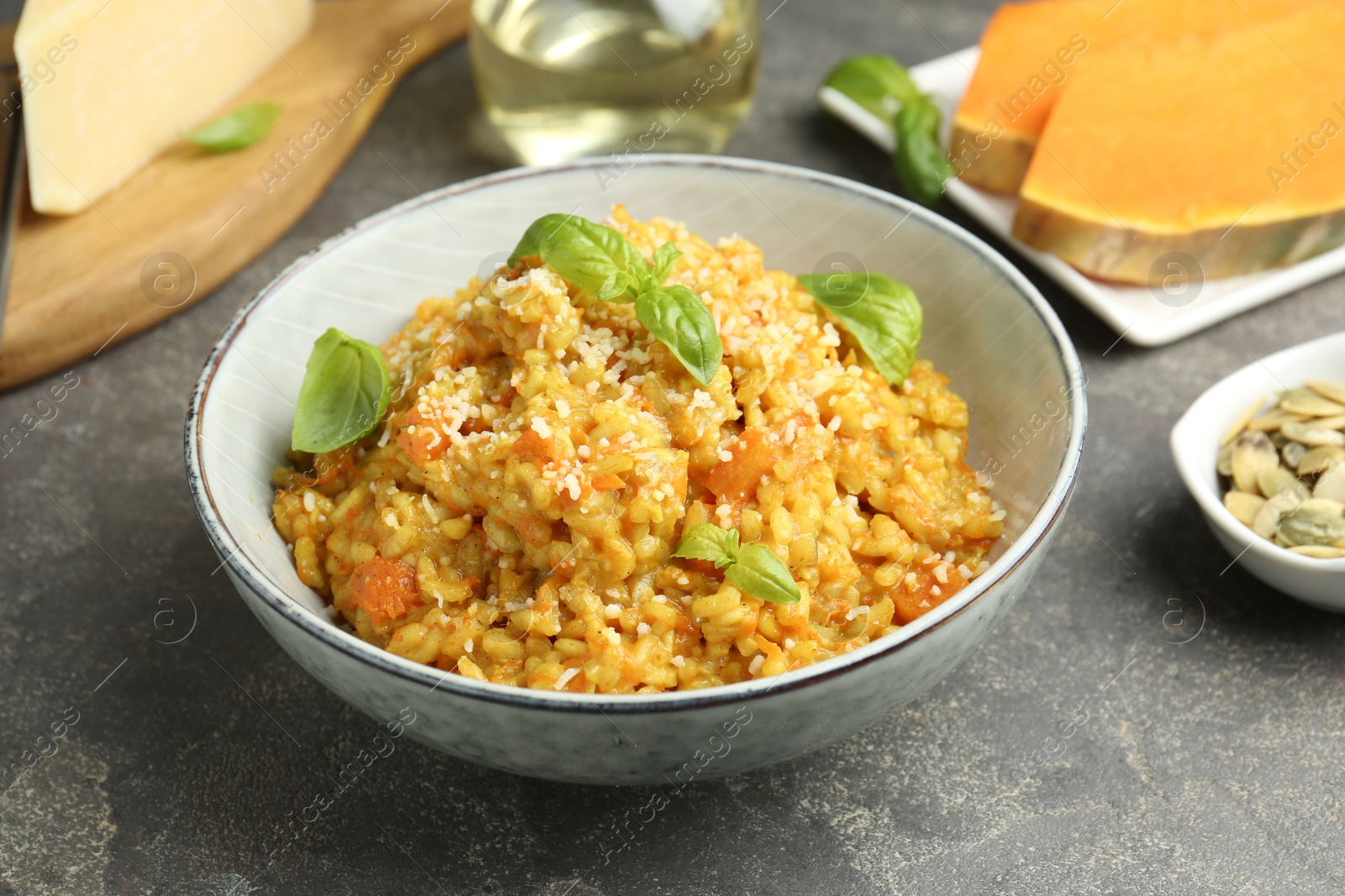 Photo of Delicious pumpkin risotto on grey table, closeup