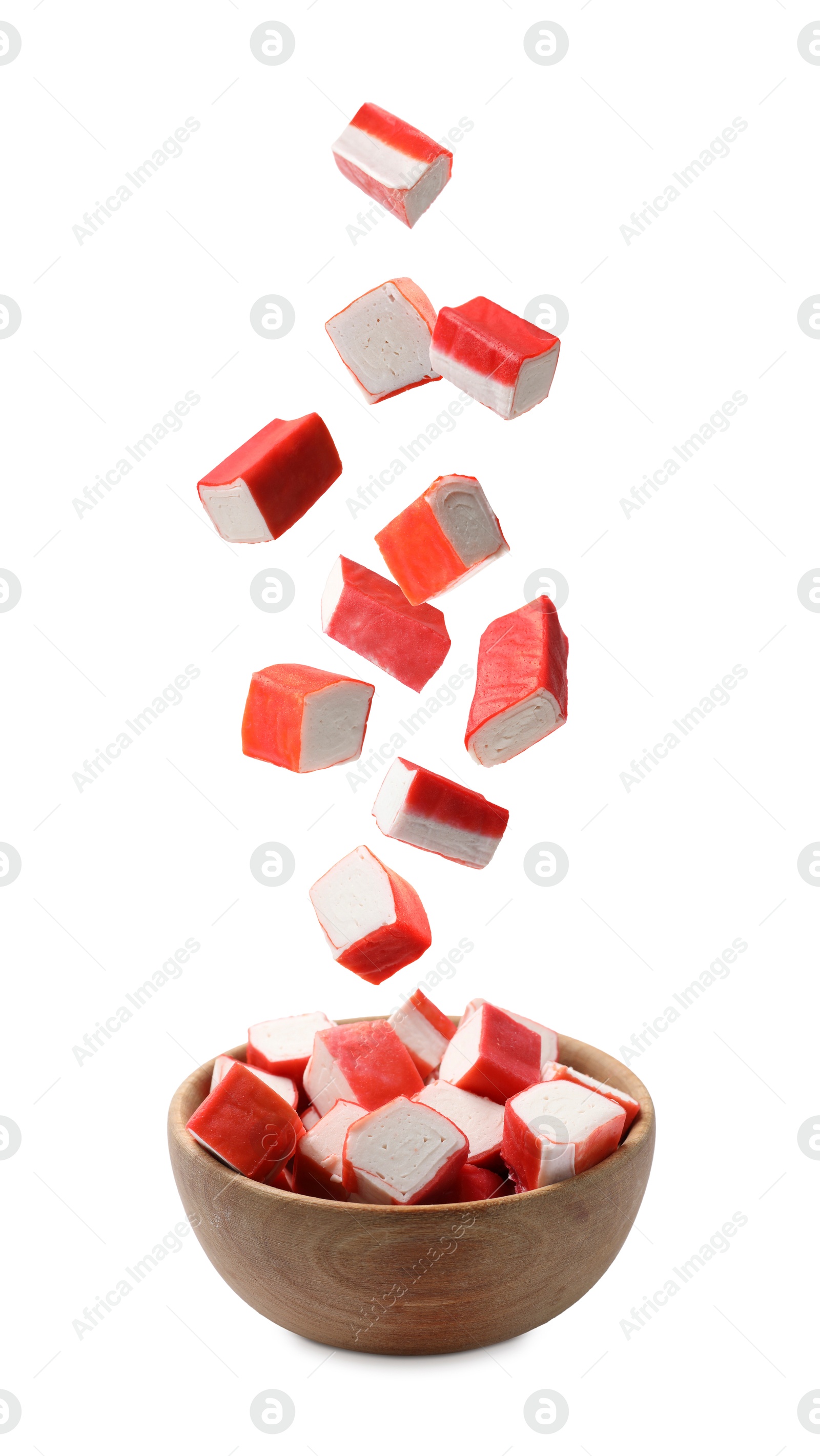 Image of Crab stick pieces falling into bowl on white background