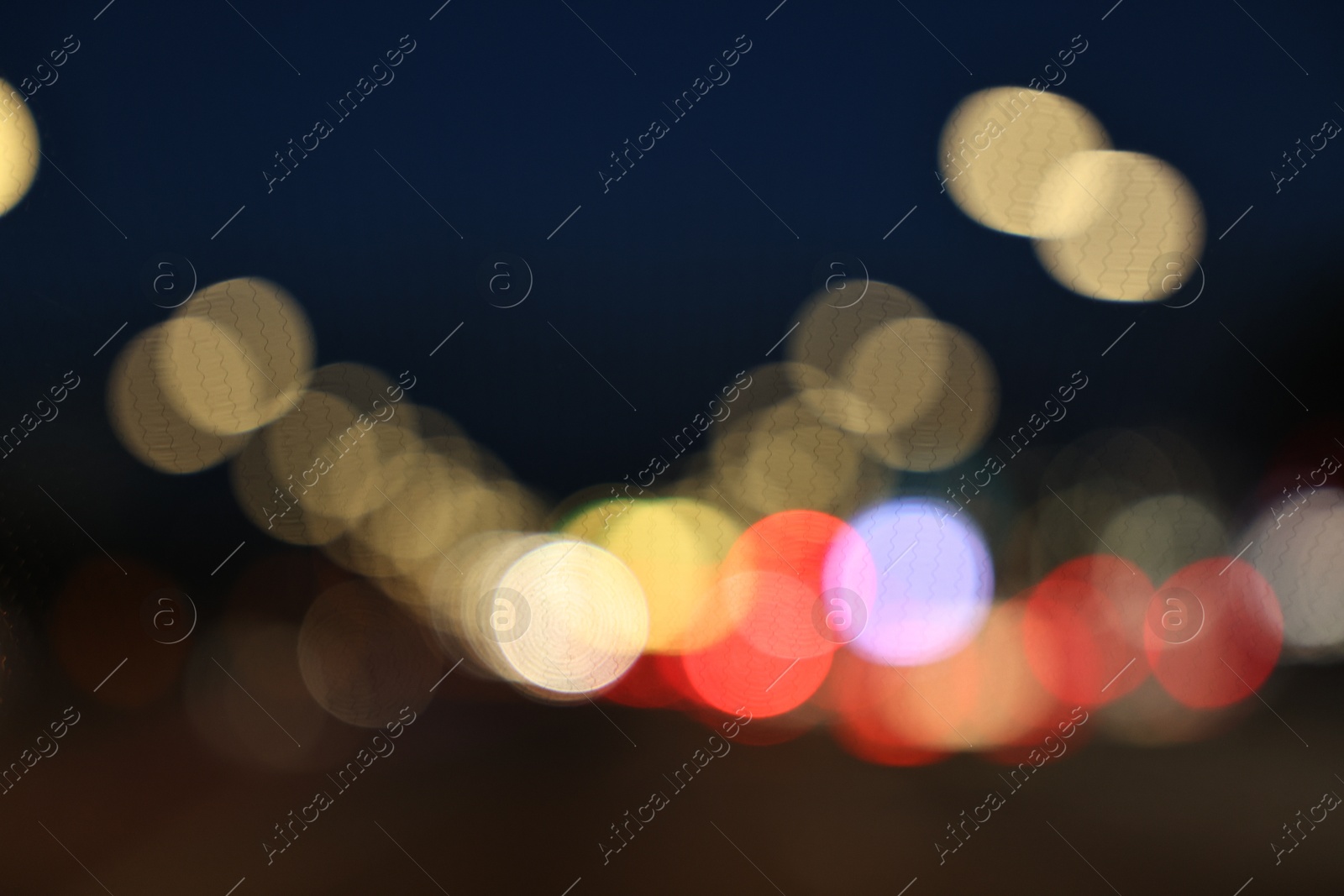 Photo of Blurred view of city street with lights at night