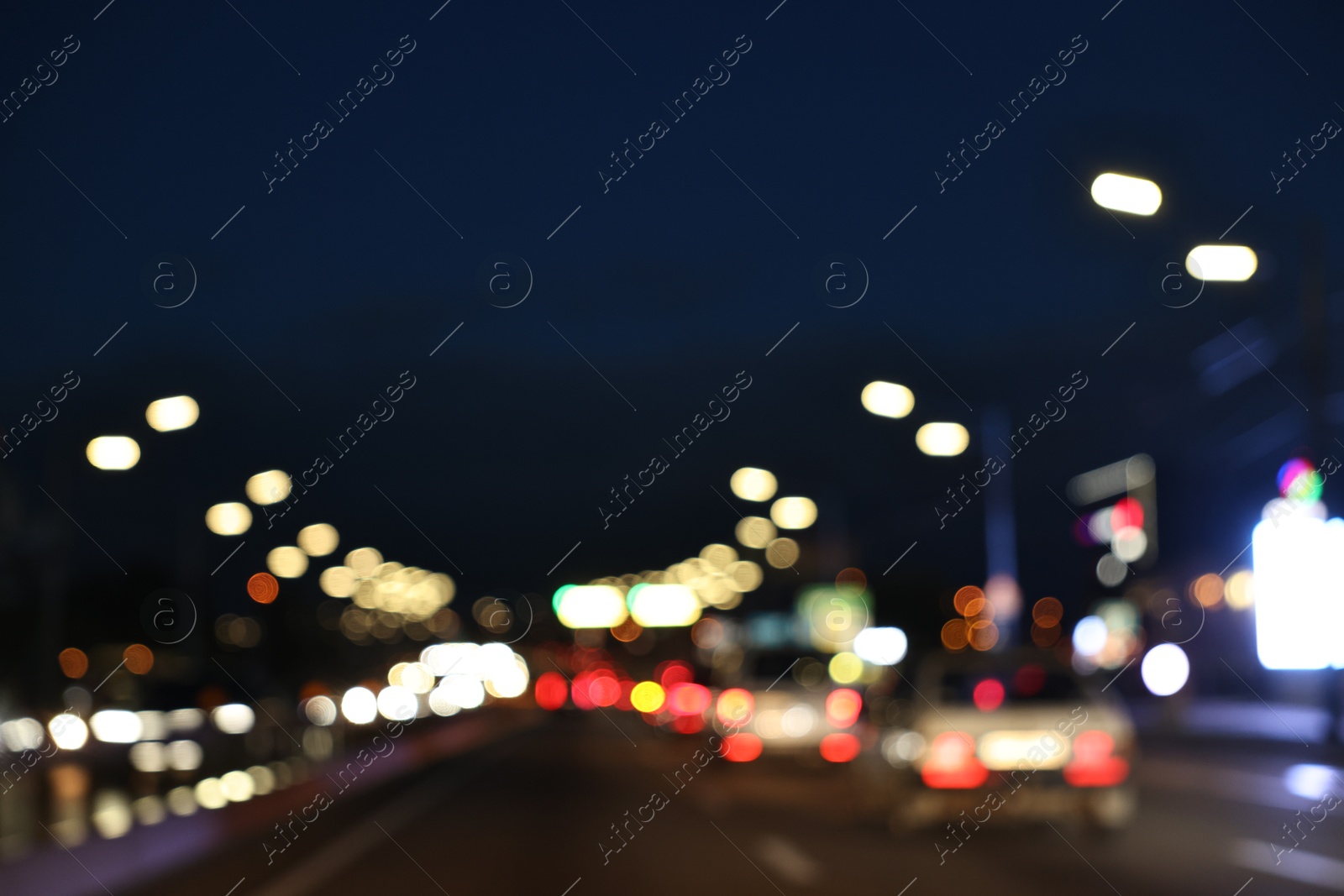 Photo of Blurred view of cityscape with road traffic and street lights in evening