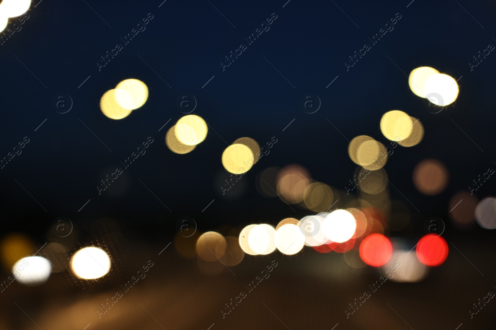 Photo of Blurred view of city street with lights at night