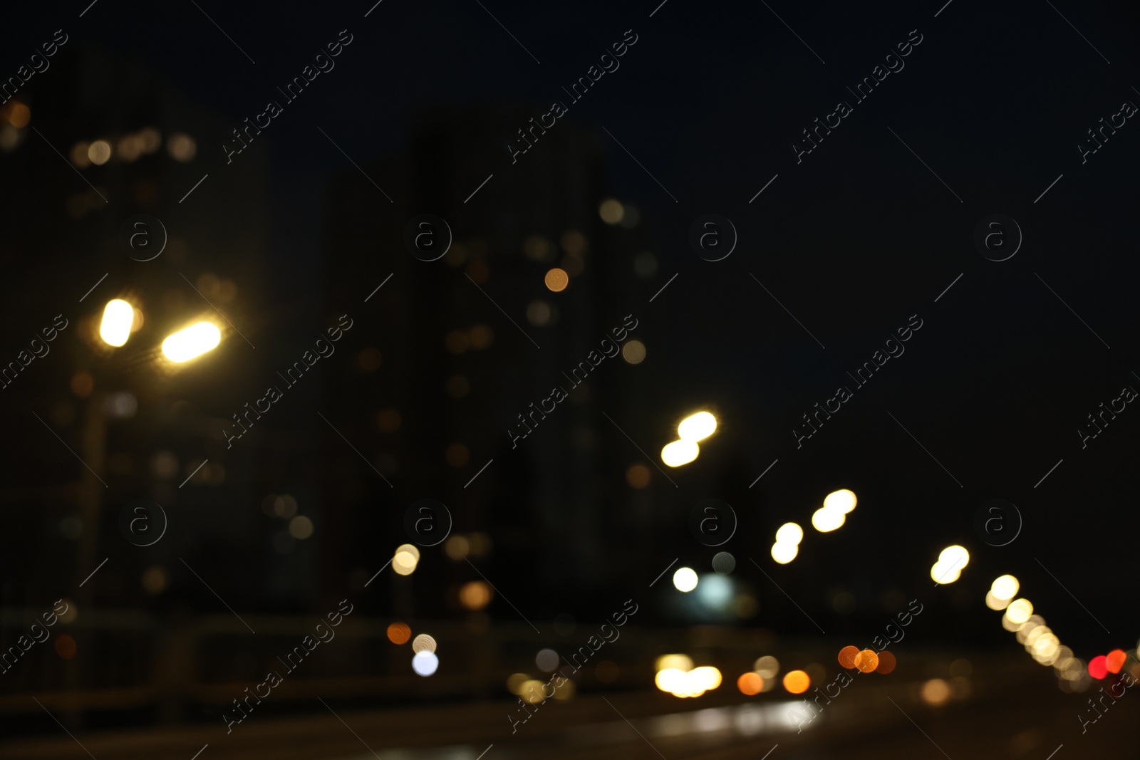 Photo of Blurred view of cityscape with road traffic and street lights at night