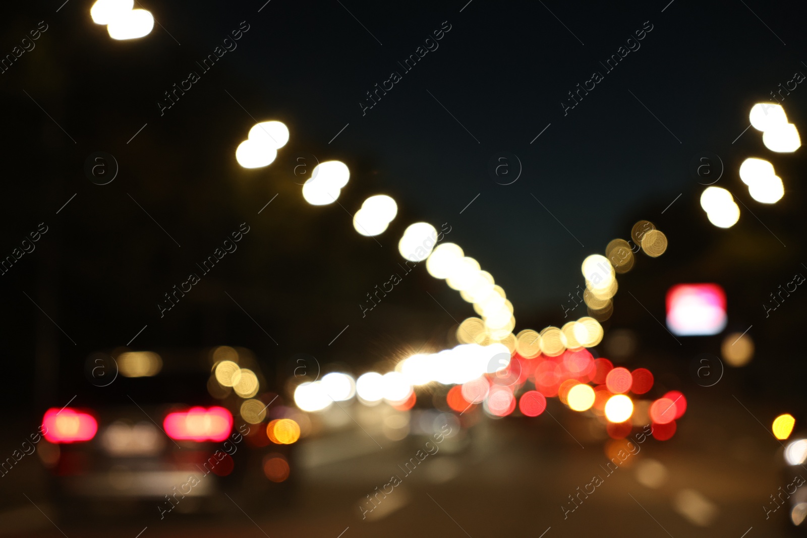 Photo of Blurred view of cityscape with road traffic and street lights at night