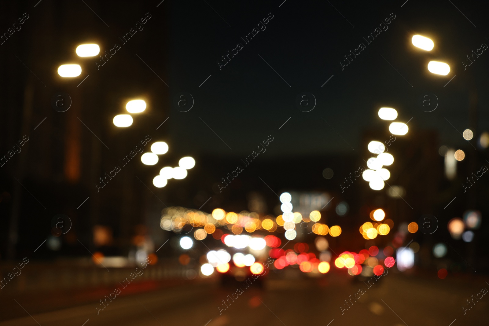 Photo of Blurred view of cityscape with road traffic and street lights in evening