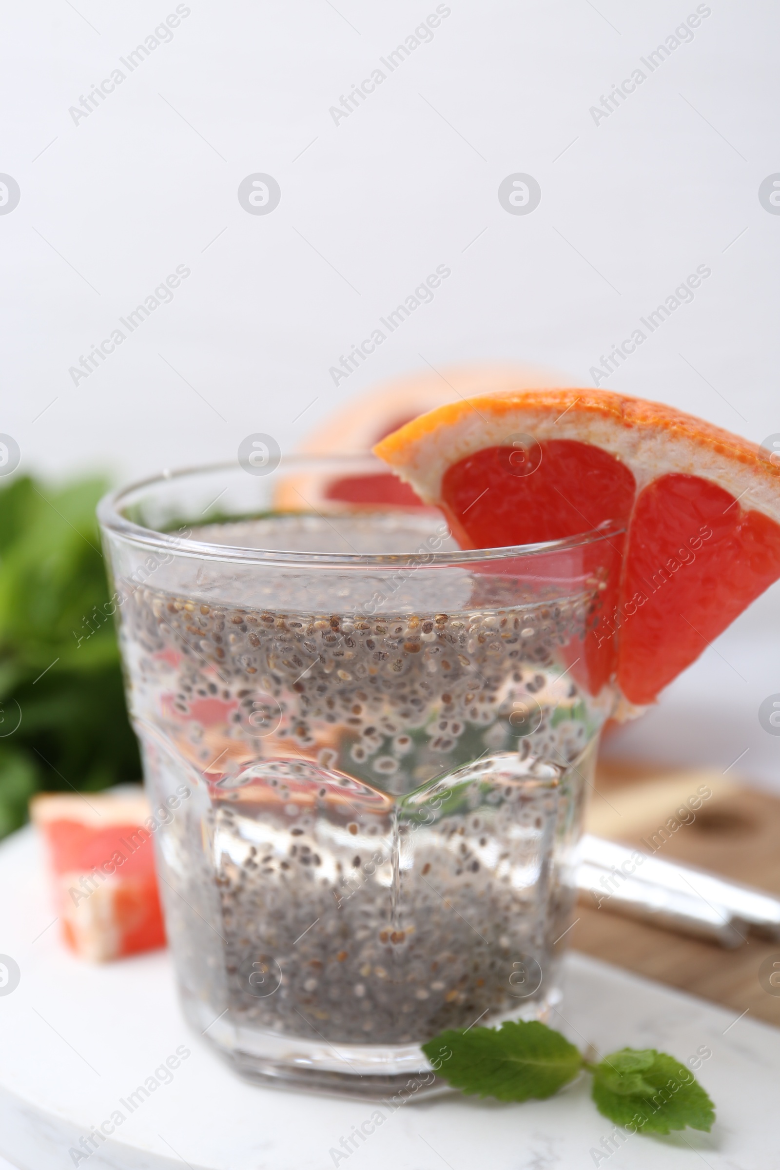 Glass of drink with chia seeds and grapefruit on white marble table, closeup Photo of Glass of drink with chia seeds and grapefruit on white marble table, closeup