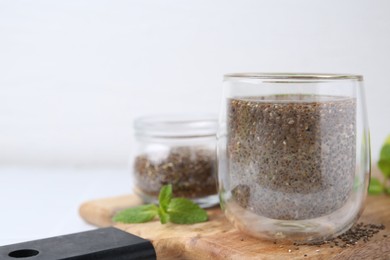 Photo of Glass of drink with chia seeds and lime on white table, space for text