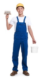 Young decorator with paint brush and bucket on white background