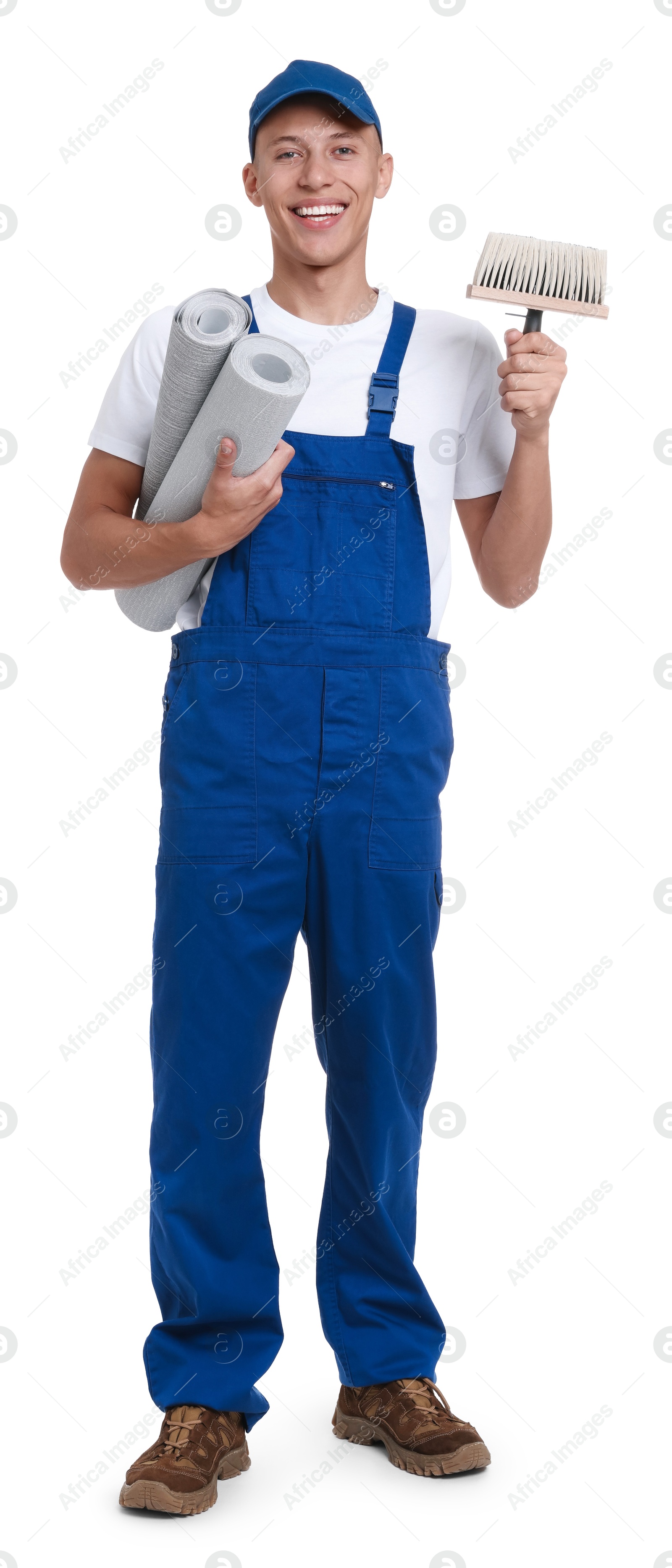 Photo of Young decorator with rolls of wallpaper and brush on white background