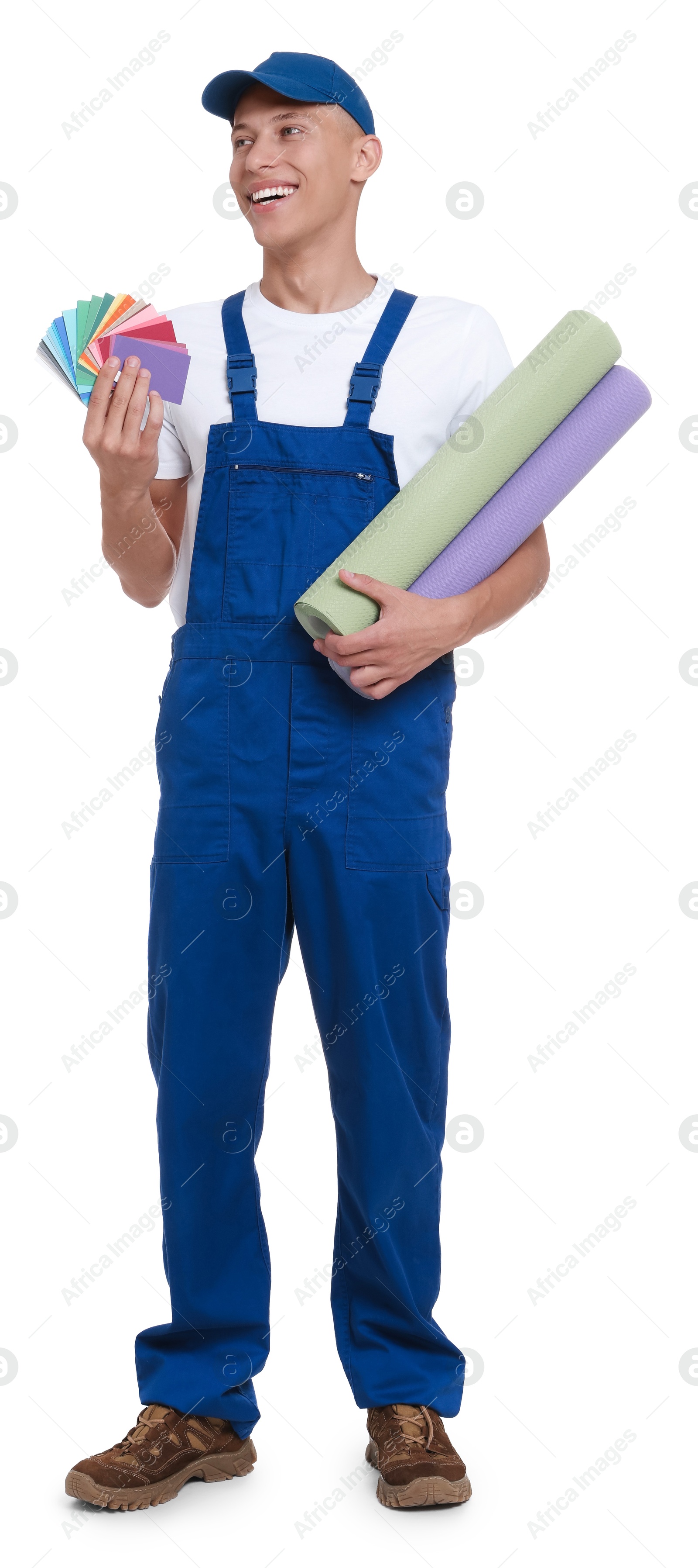 Photo of Young decorator with color palettes and rolls of wallpaper on white background