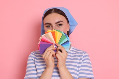 Photo of Portrait of young decorator with color palettes on pink background