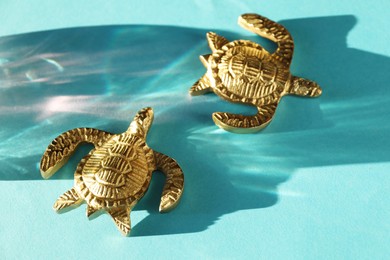 Photo of Decorative figures of turtles and beautiful shadow on light blue background