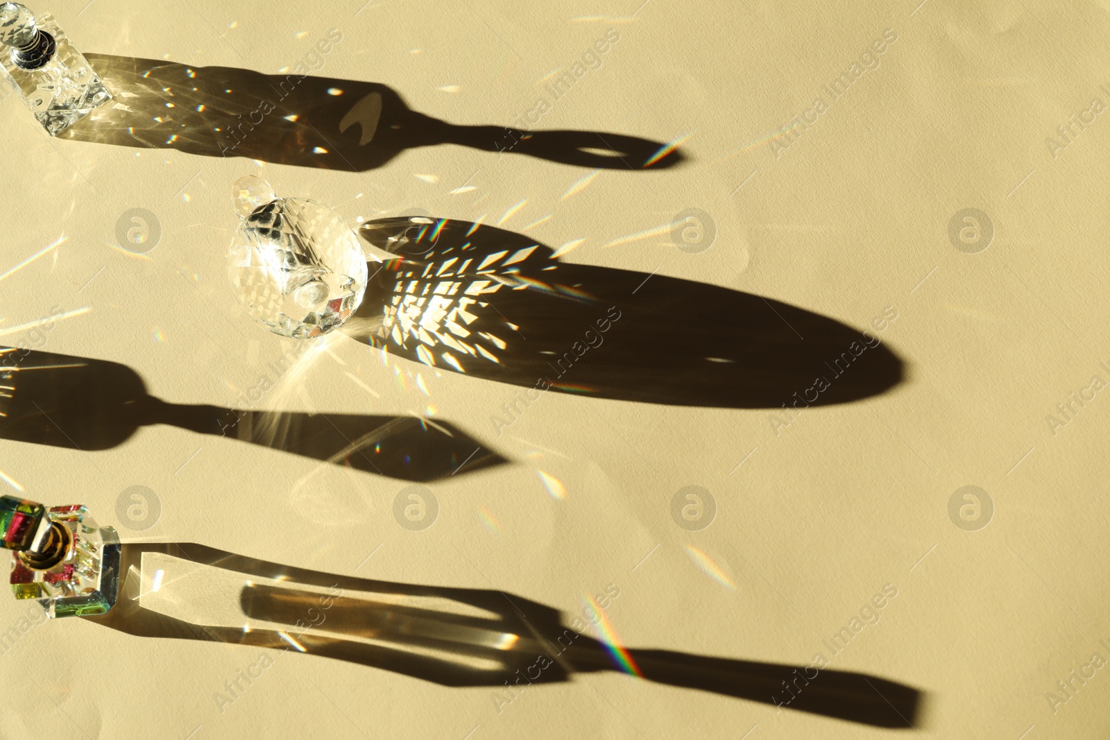 Photo of Many perfume bottles casting beautiful shadows on beige background, above view. Space for text