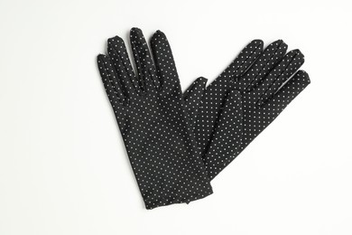 Elegant polka dot gloves on white background, top view