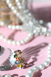 Photo of Many stylish jewelry on pink background, closeup