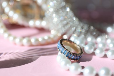 Photo of Many stylish jewelry on pink background, closeup