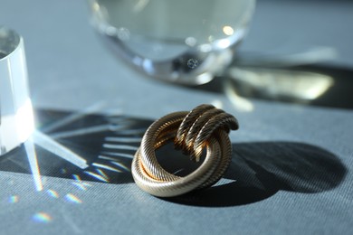 Photo of Perfume bottles and stylish earring on grey background, closeup