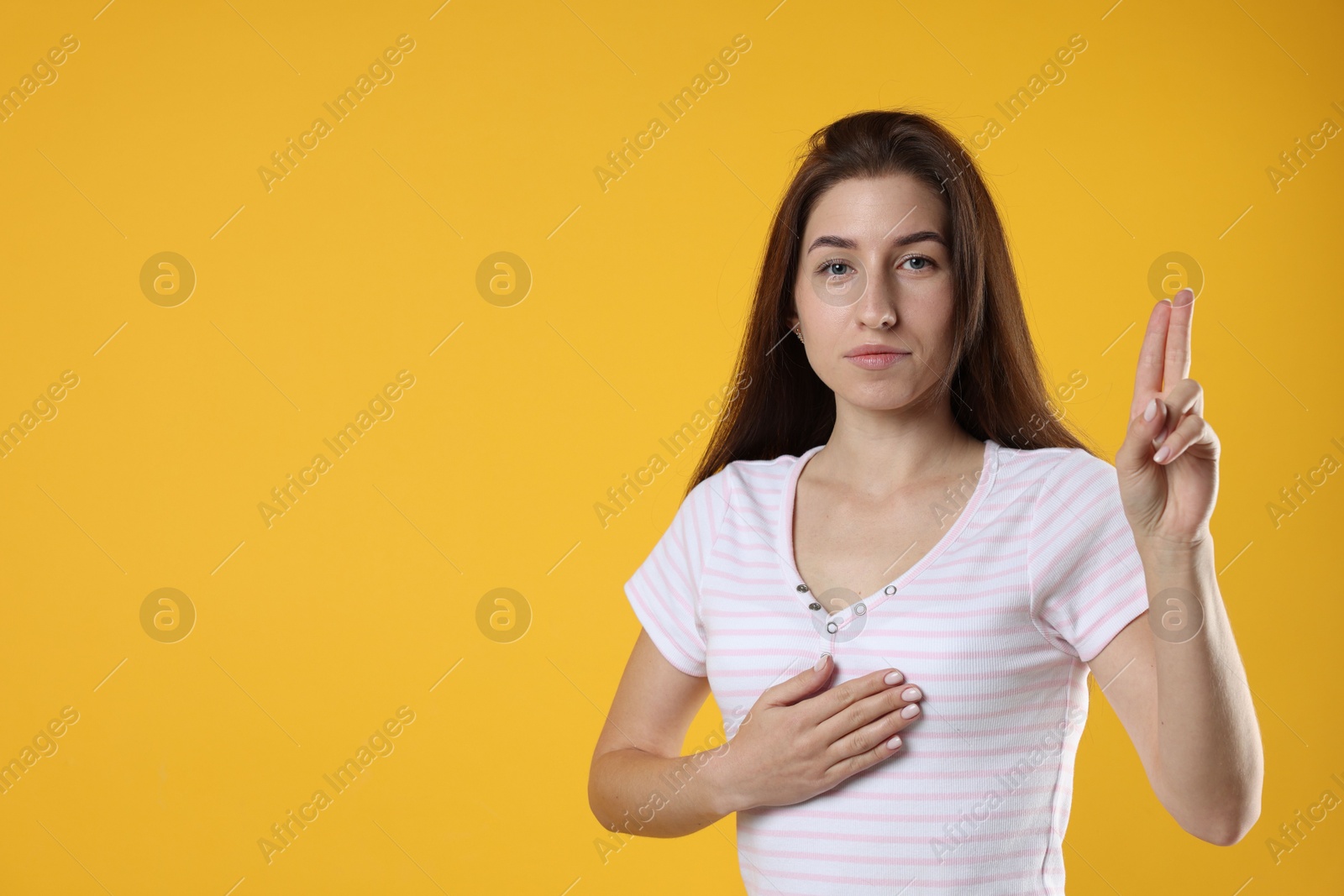 Photo of Woman showing oath gesture on orange background, space for text. Making promise