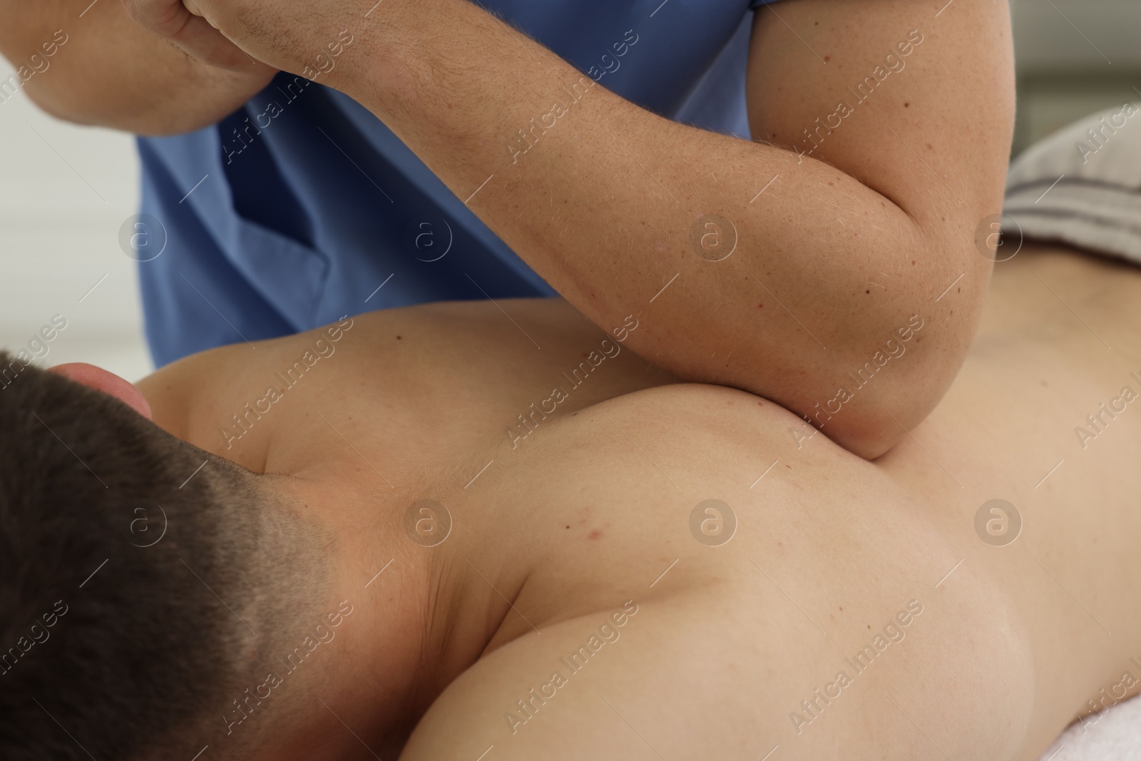 Photo of Osteopath massaging man's back in clinic, closeup. Manual therapy