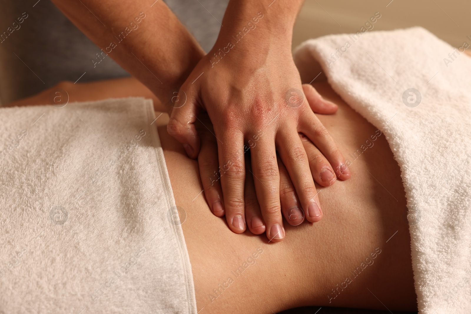 Photo of Osteopath massaging woman's belly indoors, closeup. Manual therapy