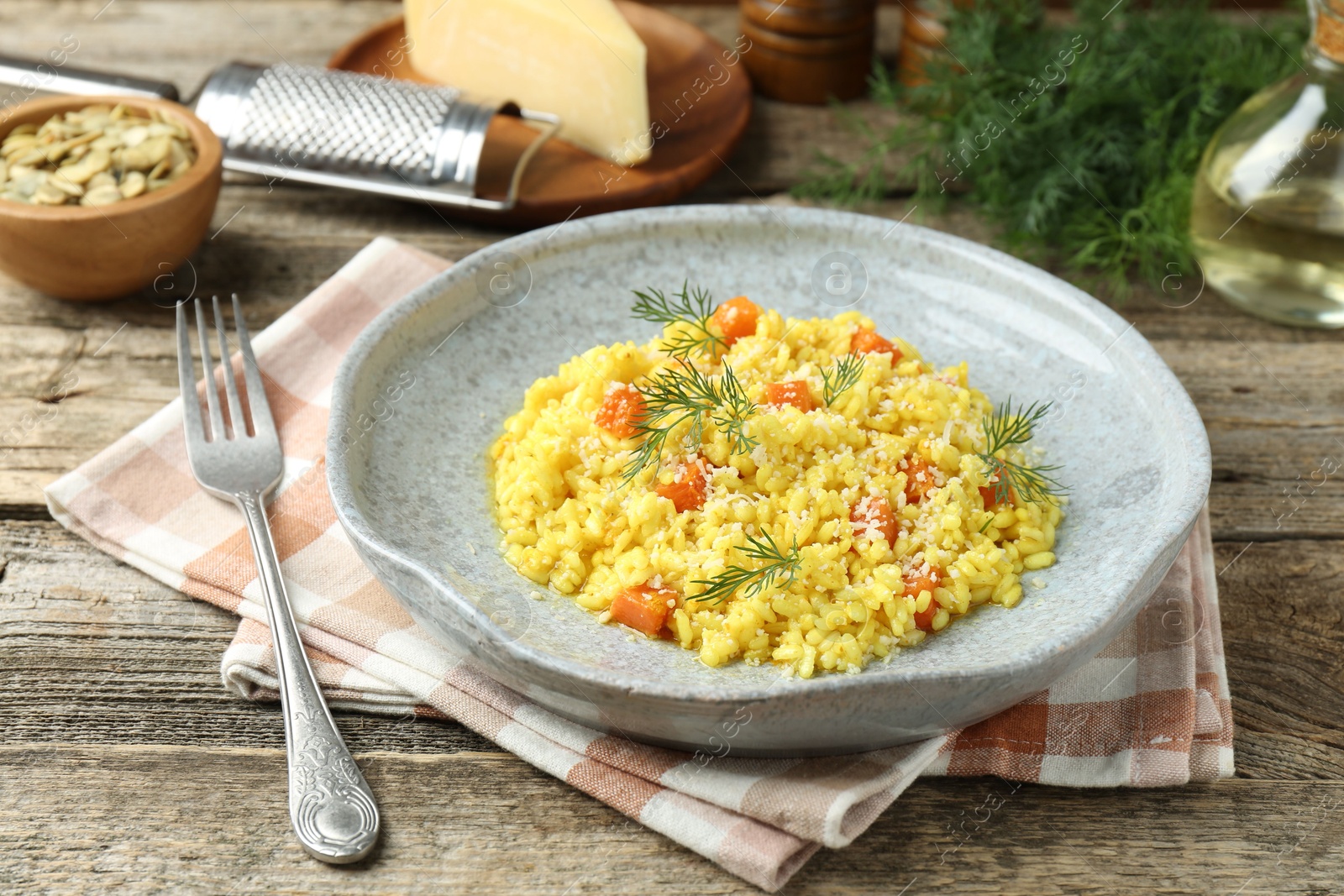 Photo of Delicious pumpkin risotto served on wooden table, closeup