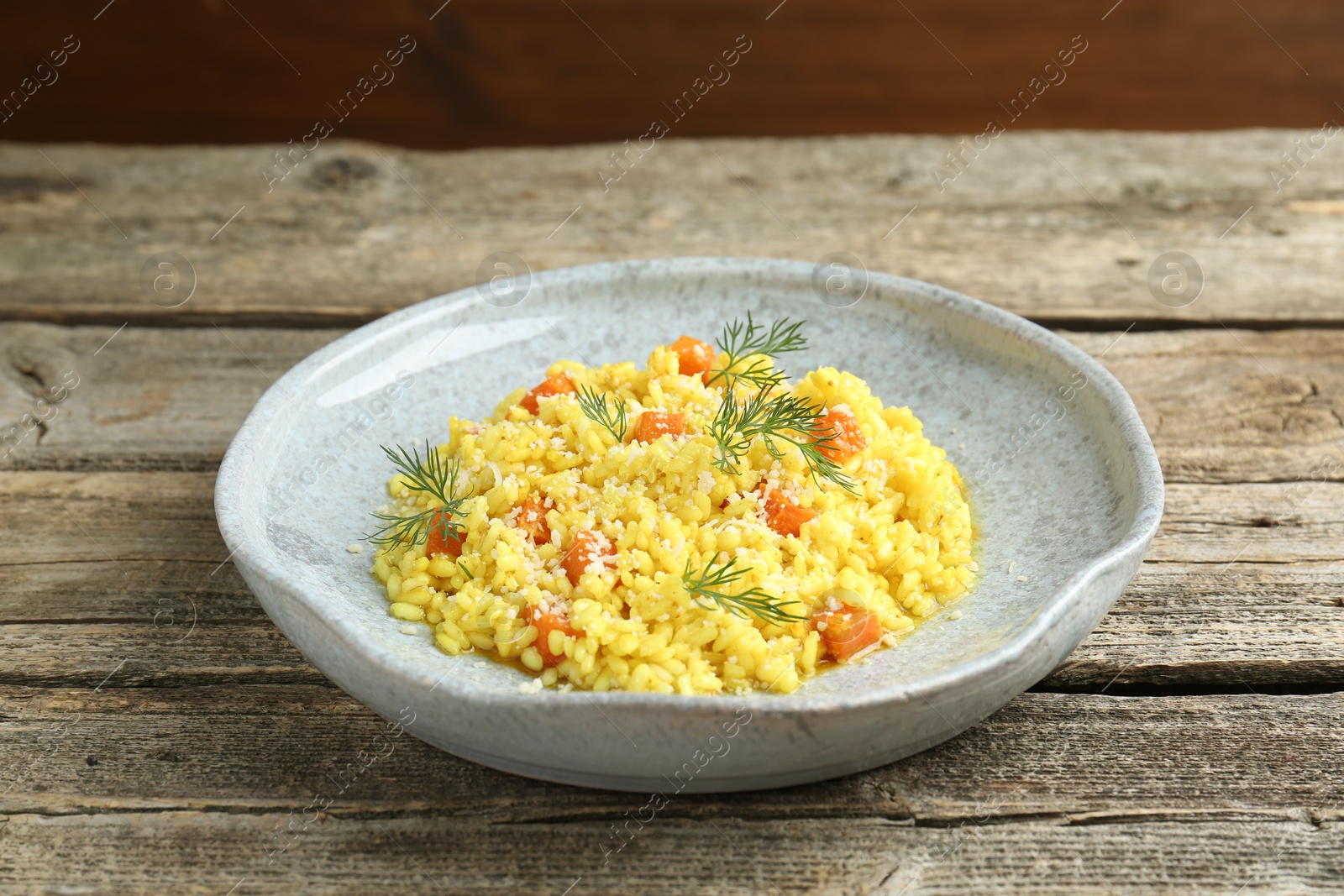 Photo of Delicious pumpkin risotto on wooden table, closeup