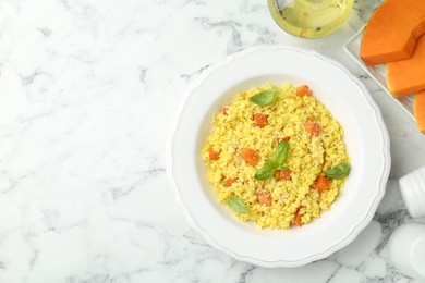 Photo of Delicious pumpkin risotto on white marble table, flat lay. Space for text