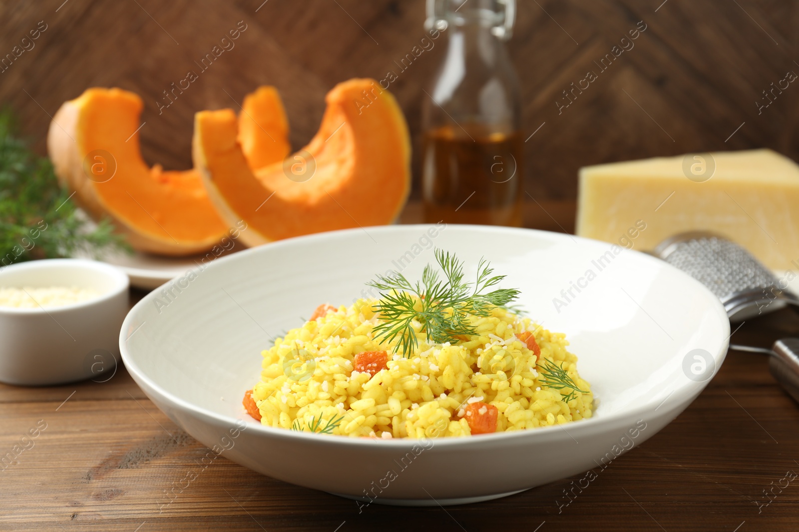 Photo of Delicious pumpkin risotto on wooden table, closeup