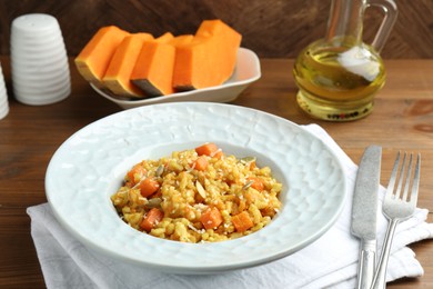 Photo of Delicious pumpkin risotto served on wooden table, closeup