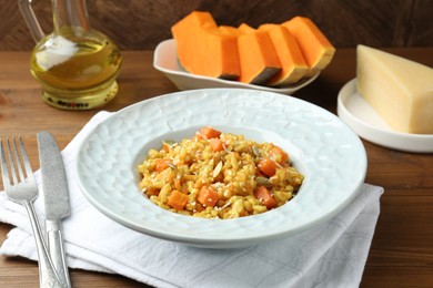 Photo of Delicious pumpkin risotto served on wooden table, closeup