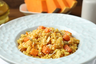 Photo of Delicious pumpkin risotto with parmesan on table, closeup